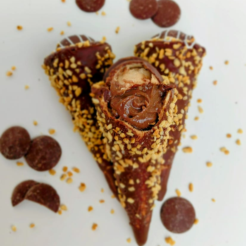Casquinha de cone crocante ,banhada em chocolate top da Harold e decotado com xerém de amendoim, com um recheio incrível de sonho de valsa, tudo feito de forma artesanal.