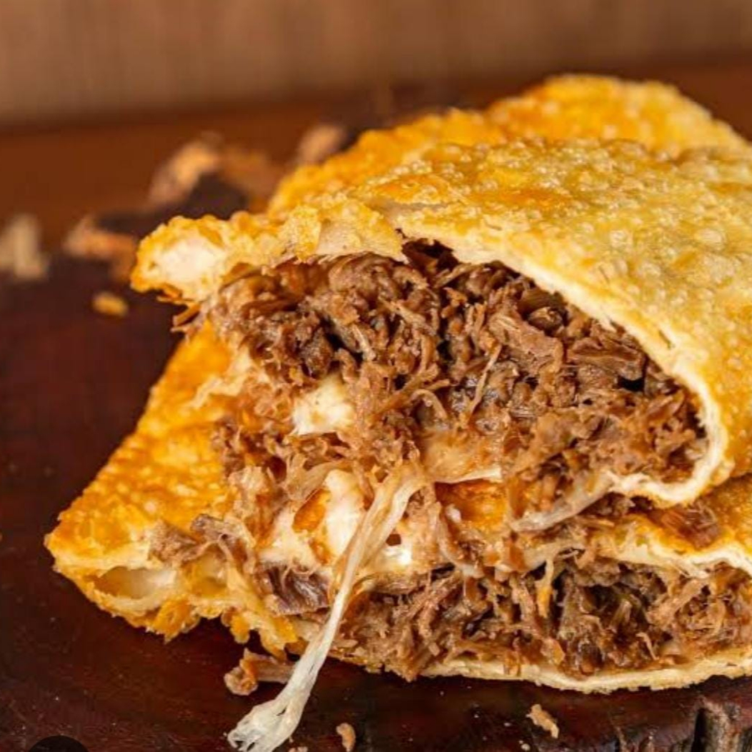 Pastel de Costela com Mussarela (20 cm) Massa crocante por fora, explosão de sabor por dentro! Costela bovina desfiada, bem temperada e suculenta, combinada com mussarela derretida que deixa tudo ainda mais cremoso e irresistível. Uma união perfeita entre sabor e textura.