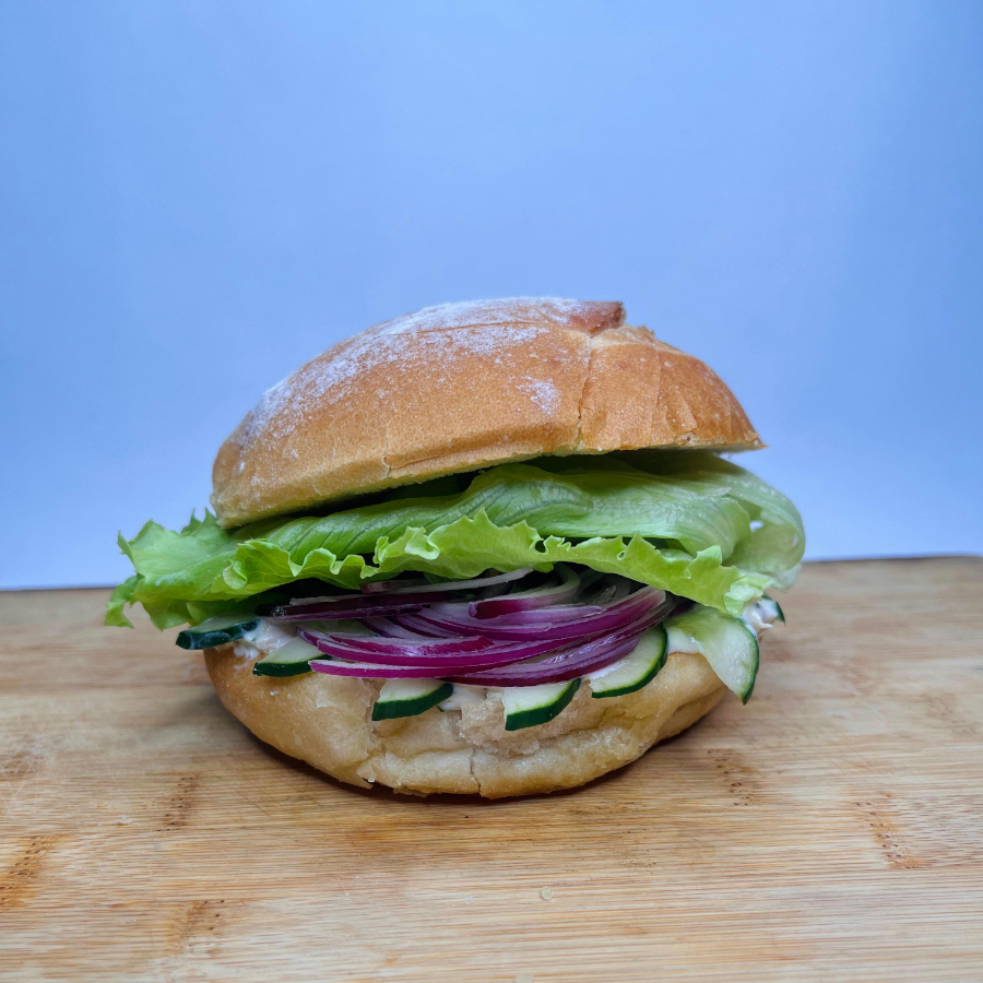 Sanduíche natural preparado com patê cremoso de atum com ricota, cebola roxa, alface americana crocante e pepino japonês fresco, servido em pão de fermentação natural. Leve, fresco e saboroso, ideal para uma refeição equilibrada.