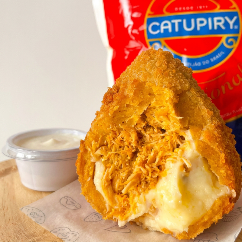 A coxinha que está todo mundo pedindo! Massa leve de batata, recheio generoso de frango bem temperadinho com Catupiry® original, empanada em farinha panko para máxima crocância. Super recheada, dourada e frita na hora. Um salgado viciante e irresistível.