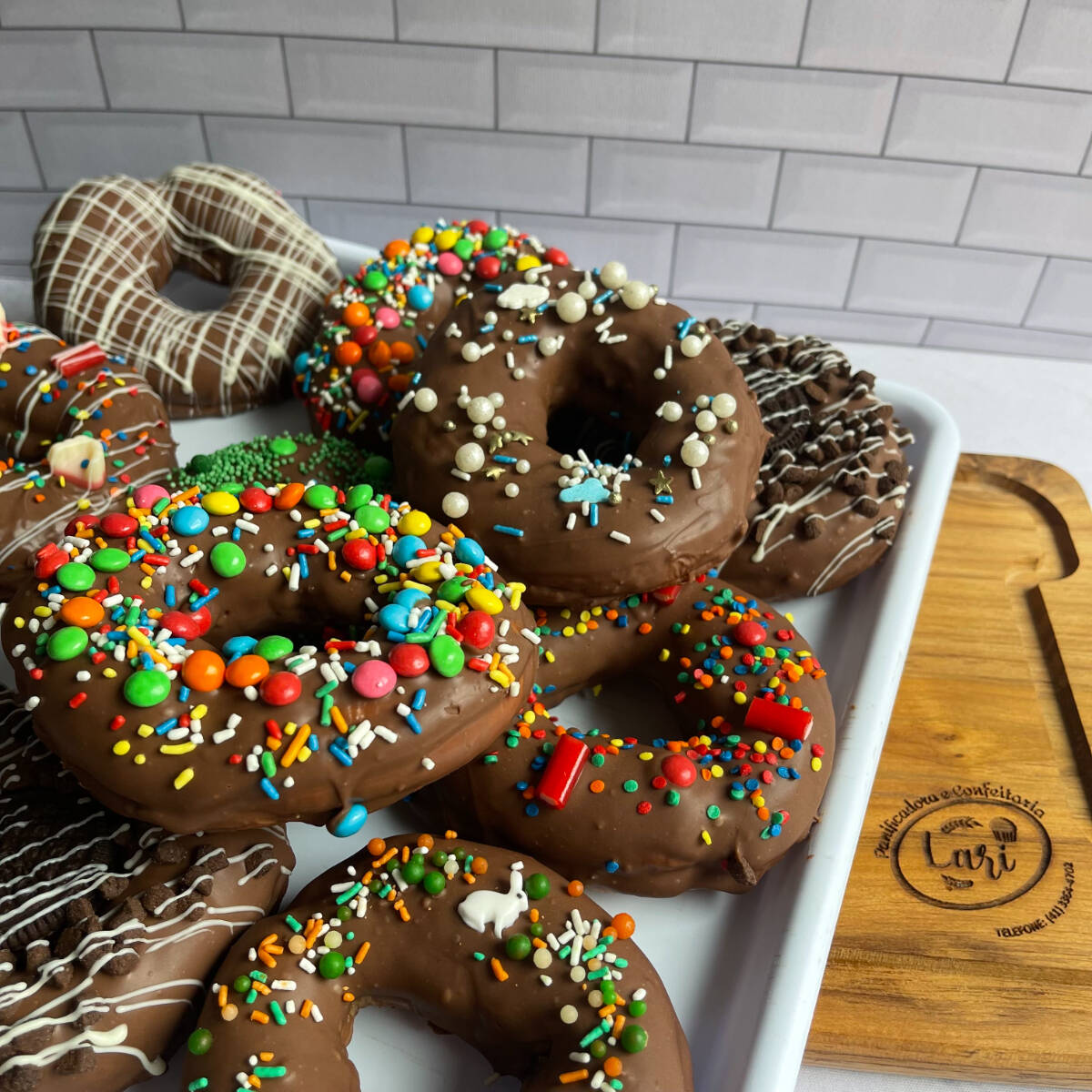 Um donuts feito com massa frita e recheio de brigadeiro, cobertura de chocolate. Decoração aleatória.