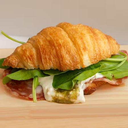 Bem-vindos ao Bela Vista. A união perfeita do croissant francês com as mais deliciosas iguarias italianas: molho pesto de manjericão, stracciatella di búfala, salame italiano e rúcula. Experimente e conte para a gente o que achou. Servido frio.