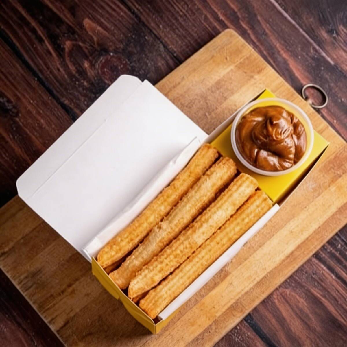Desfrute de seis irresistíveis churros espanhóis, meticulosamente preparados na hora e envoltos com maestria em uma mistura de açúcar e canela de sabor marcante. Estes churros são sempre entregues perfeitamente sequinhos, garantindo uma textura excepcionalmente crocante e um interior suave, proporcionando uma experiência gastronômica verdadeiramente memorável. Aprecie o autêntico sabor da Espanha