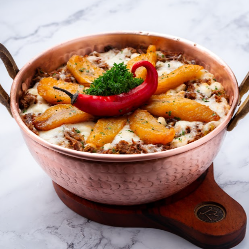 Arroz cremoso, carne de sol desfiada, cebola roxa, cubos de queijo coalho, ervas finas e banana frita.