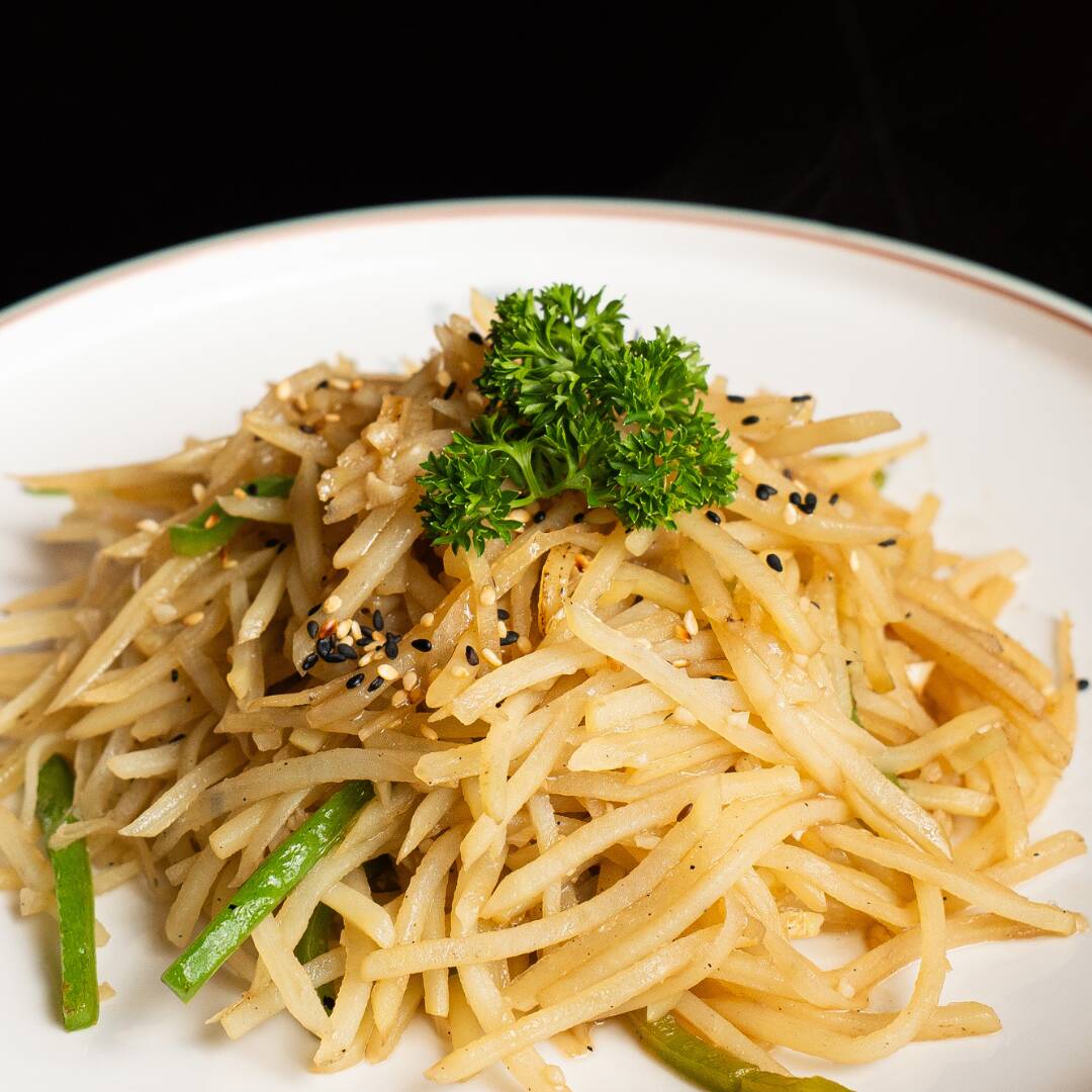 Tiras de batata salteada com pimentões, vinagre de arroz e alho.