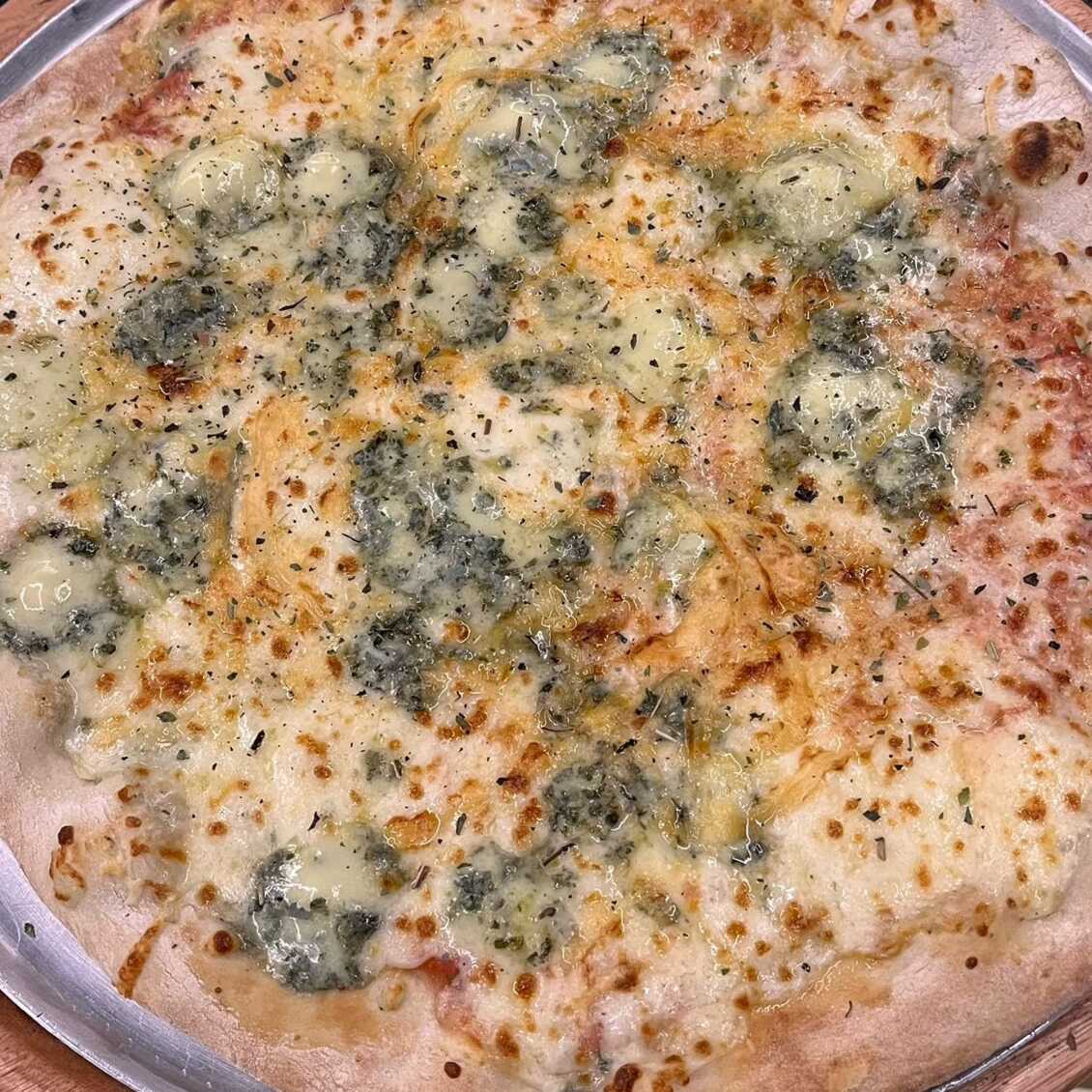 Molho pelati, muçarela, gorgonzola, provolone, catupiry e orégano.