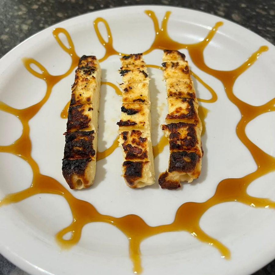 Três tabletes de queijo coalho assado na brasa.