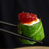 Couve fresca envolvendo arroz com creme de castanha de caju e uma geleia artesanal de pimentão vermelho adocicada.