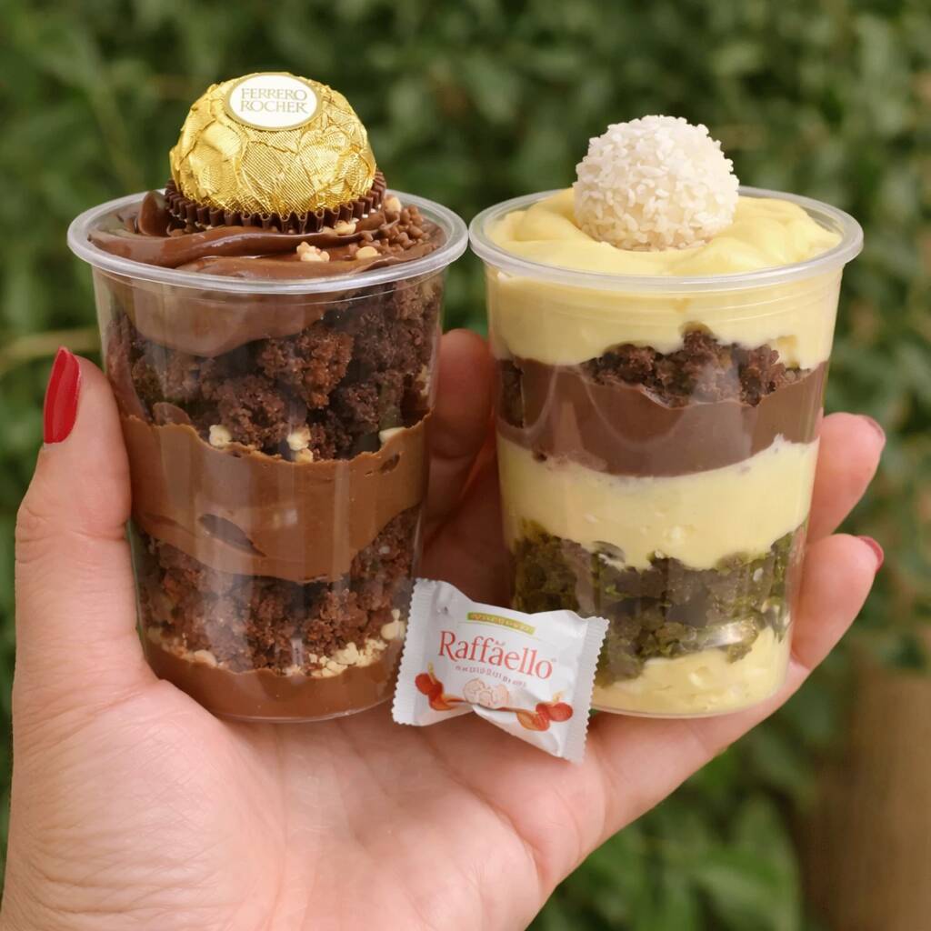 Dois copos da felicidade irresistíveis em um só combo! 150gr cada copo 🍫🥥 Um delicioso copo sabor Ferrero, com camadas de bolo de chocolate, creme de chocolate cremoso, pedaços de brownie e finalizado com um Ferrero Rocher por cima. E o clássico Rafaello, com camadas de bolo, creme branco super cremoso, chocolate e finalizado com o famoso Rafaello de coco. Uma combinação perfeita para quem ama chocolate e quer provar dois sabores incríveis no mesmo pedido! 😍✨