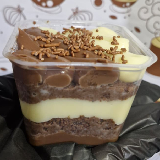 Um delicioso bolo no pote 2 amores, feito com 2 camadas de massa de chocolate, 1 camada de Ninho e outra de brigadeiro, finalizando com camada mista e granulado