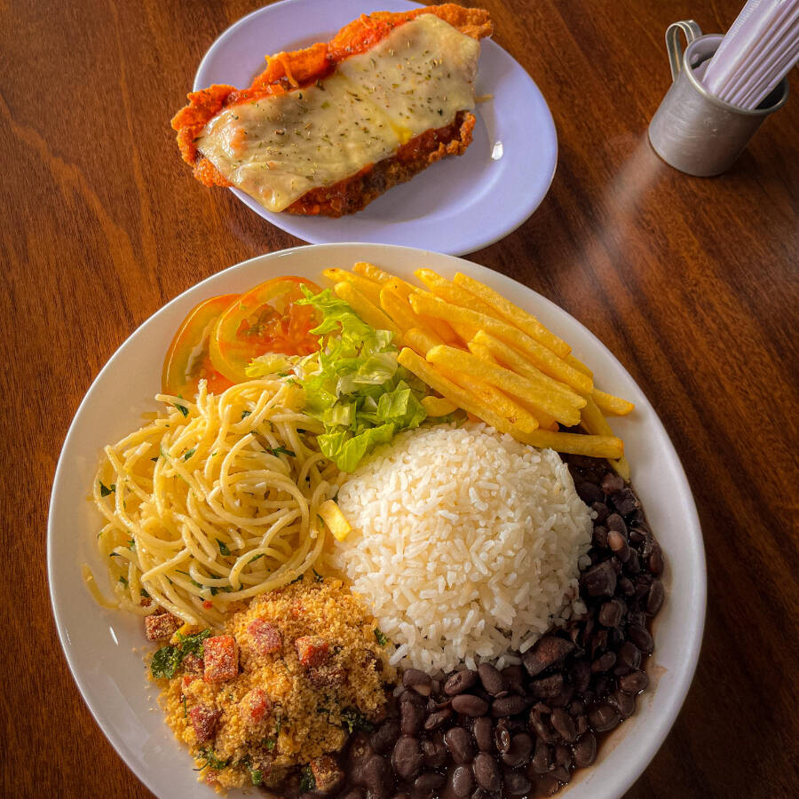 Aroz branco, feijão, farofa, macarrão, refogado do dia, batata frita, salada de alface americana e tomate e Bife Parmegiana