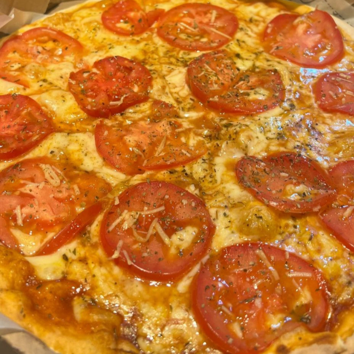 Massa com fermentação natural e artesanal, molho de tomate especial caseiro, queijo mussarela, tomate em fatias, queijo parmesão e orégano.