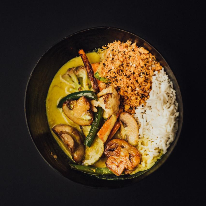 Molho tailandes à base de leite de coco, coentro, gengibre e especiarias servido com legumes, cogumelo, arroz basmati e farofa de gergelim. Este prato é vegano.