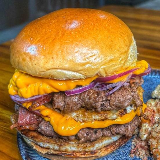 🍔 O Melhor Cheddar da Sua Vida
Pão de brioche na manteiga, 240g de Blend Especial (2 de 120g), 2 ovos (um em cada camada), bacon defumado crocante, cebola roxa fininha e muito cheddar cremoso.
🎁 Cortesia: Ganhe Batata Rústica + Super Maionese Temperada.