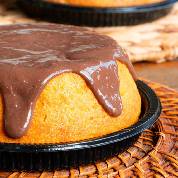Delicioso bolo de cenoura caseiro com uma generosa cobertura de chocolate ao leite.