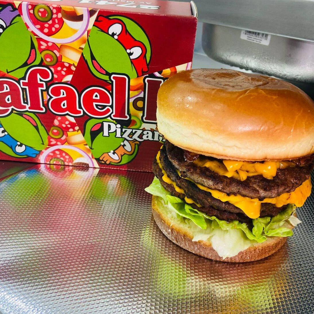 PÃO DE BRIOCHE, 2 HAMBURGUERES, QUEIJO PRATO, PRESUNTO, BACON, ALFACE, TOMATE E MAIONESE VERDE