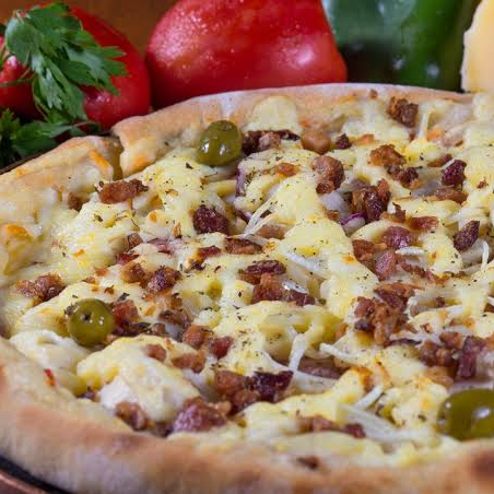 Molho de tomate, calabresa moída, palmito, bacon e mussarela, tomate e parmesão.