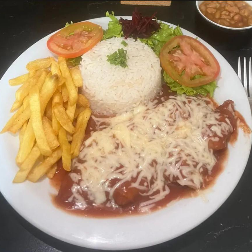 Frango à Parmegiana é uma deliciosa combinação de sabores. O frango, cuidadosamente empanado e frito, coberto com um molho de tomate e queijo derretido, acompanhado de um arroz fresco, batatas chips uma salada fresca.
Marmita redonda de isopor.