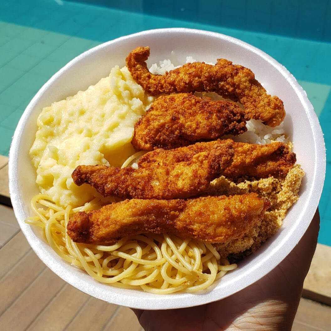 São iscas de frango a milanesa acompanhado de arroz branco, feijão, farofa, macarrão e mais um complemento