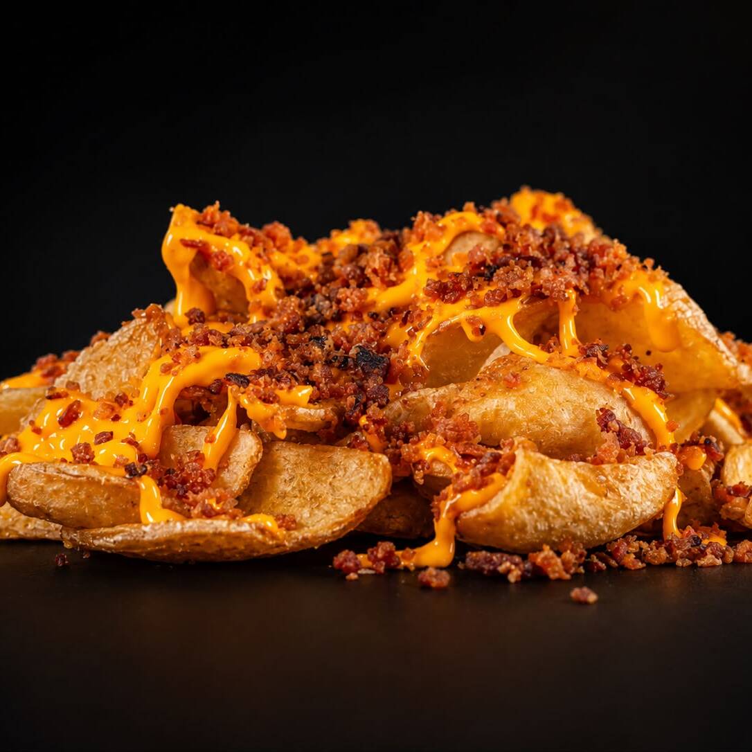 Batata canoa frita, molho cheddar e farofa de bacon. ( Aprox. 430g )