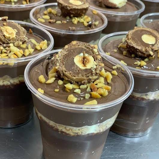 Delicioso copo da felicidade Ferrero com creme de Avelã, chocolate e amendoins granulados e no topo um delicioso bombom Ferrero