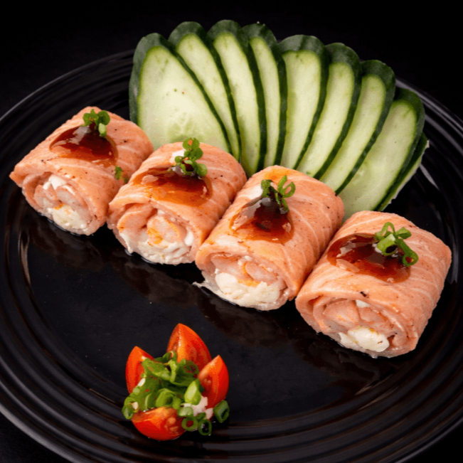 Lâminas de salmão envolvem suculentos camarões e cream cheese, tudo perfeitamente maçaricado. Cada porção é finalizada com um toque especial de molho teriyaki e cebolinha.