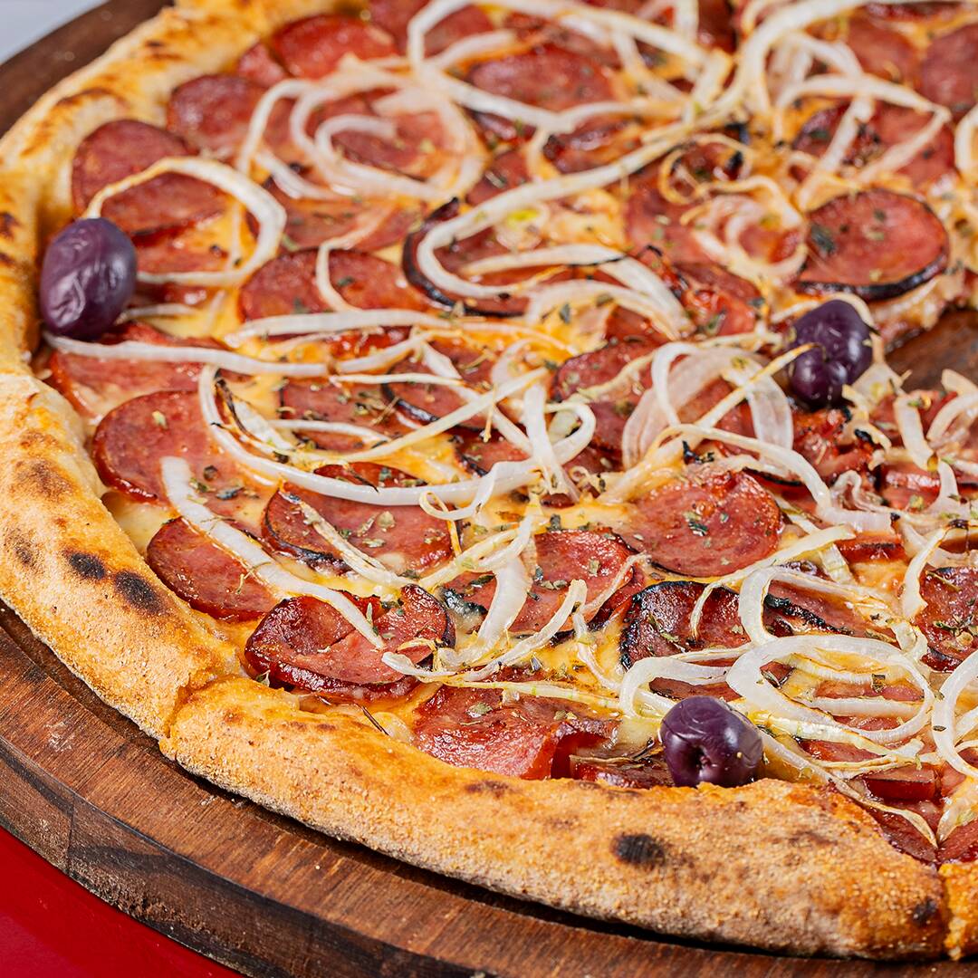 Molho de tomate autêntico coberto com calabresa de primeira, cebola fatiada, orégano e azeitonas pretas.
