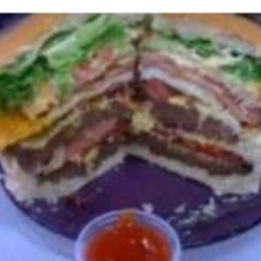 Pão, 2 Hamburgueres de 90g, bacon, 2 ovos, presunto, mussarela, cheddar, abacaxi, alface, tomate, milho, batata palha e maionese da casa