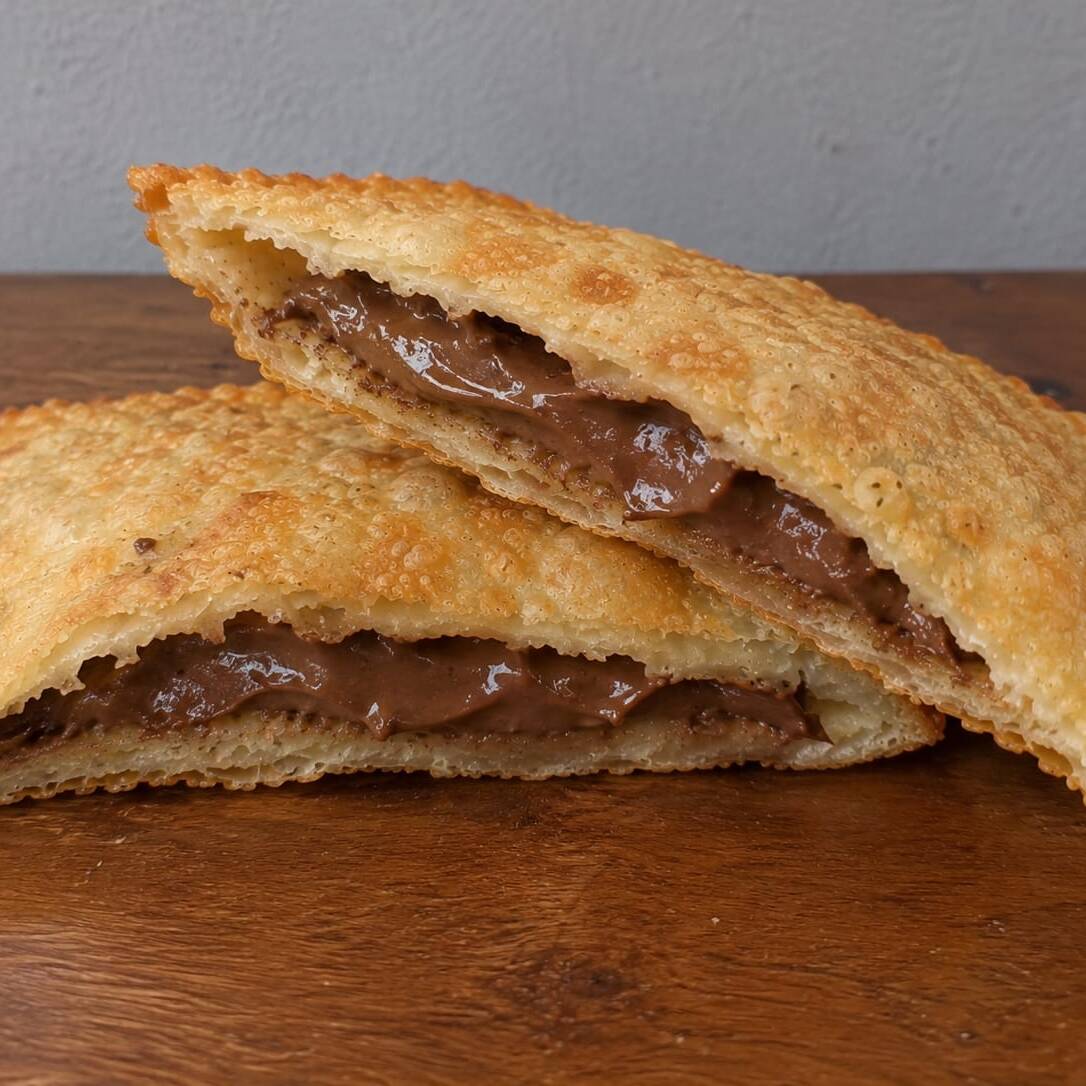 A sobremesa perfeita para fechar com chave de ouro! Nossa massa artesanal super crocante, douradinha e sequinha, recheada generosamente com muito chocolate ao leite cremoso e derretido
