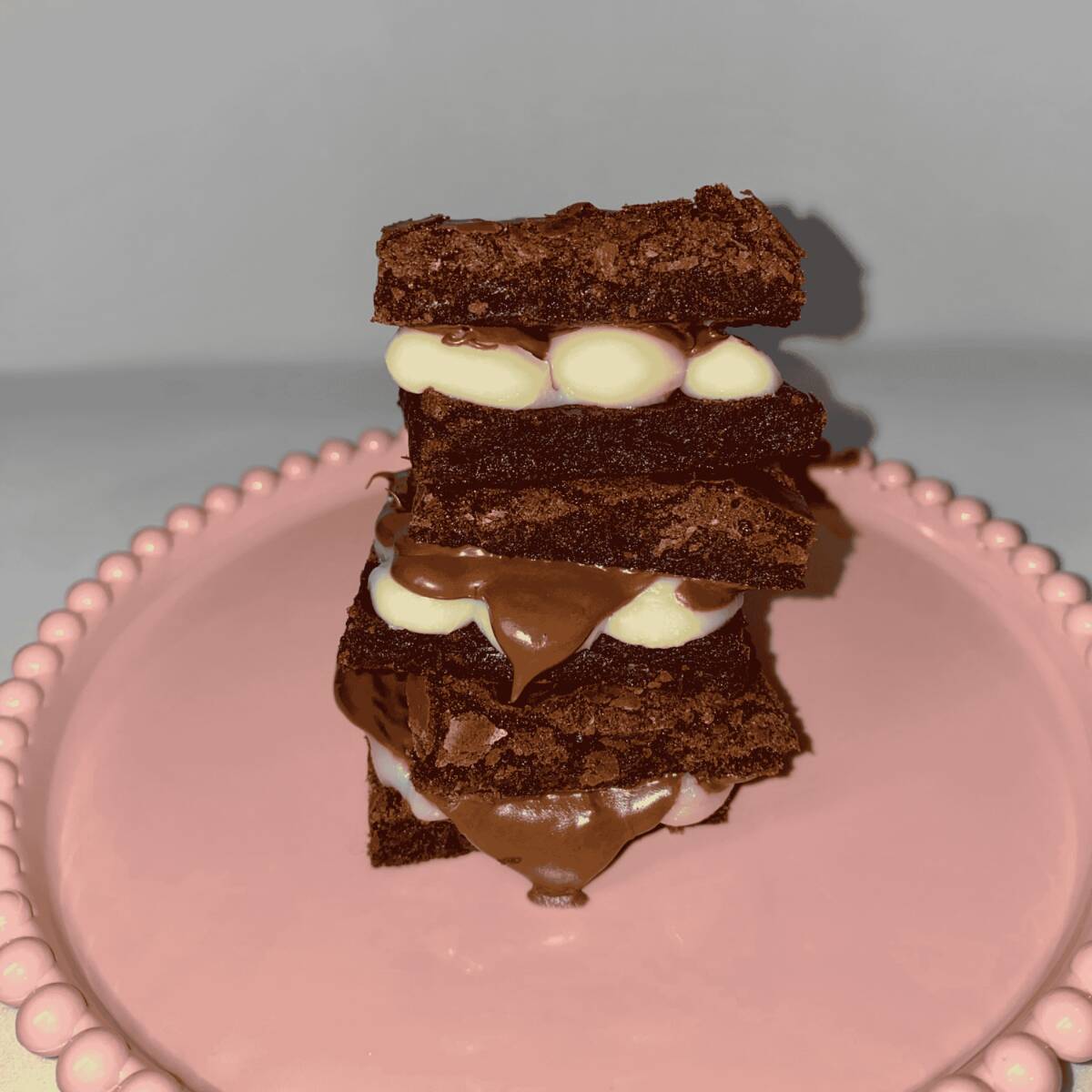 Nossa deliciosa massa de brownie super chocolatuda com gotas de chocolate ao leite, no tamanho 5x5 cm, com muito recheio de Ninho com Nutella pura e Original!