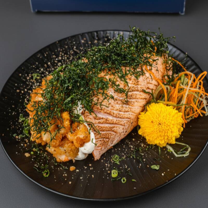 Temaki coberto por manta de salmão, arroz japonês recheado com: Opção 1: camarão e skin empanado e cream cheese. Opção 2: Só camarão empanado e cream cheese.