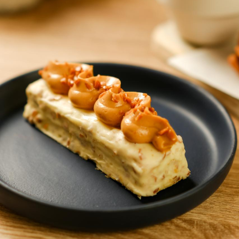 Barra gelada feita com creme de doce de leite e cream cheese,biscoito champagne embebido em café,com cobertura de mousse e crocante de caramelo salgado.