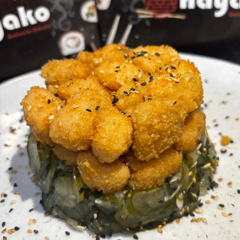 Delicie-se com uma entrada de sunomono crocante de salmão, peixe branco, kani, pepino e gergelim, perfeita para abrir o apetite com sabores frescos e texturas variadas.