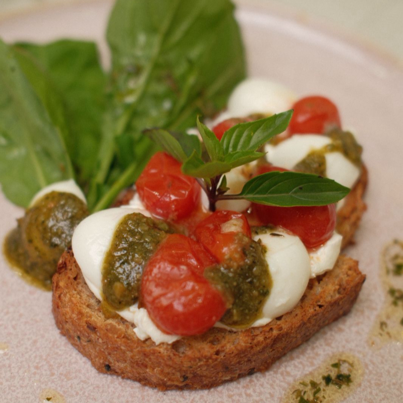 Combinação perfeita de tomate confitado no azeite, mussarela de búfula, pesto e pão tostado, acompanhado de rúcula. Refrescante, aromático e com sabor mediterrânio.