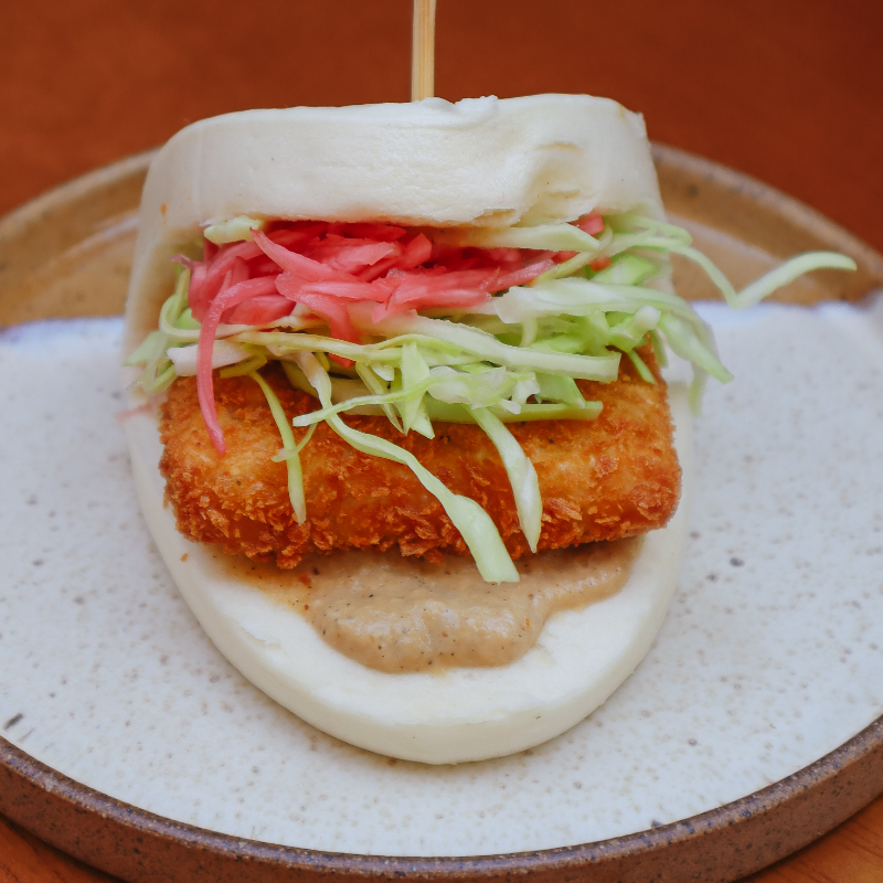 Pão chinês cozido no vapor, recheado com tonkatsu de tofu defumado, maionese de cebola caramelizada no missô com uma deliciosa saladinha de repolho e picles de rabanete.