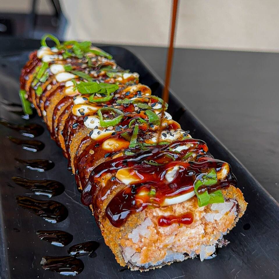 Delicioso hot roll no formato de hot dog composto por salmão grelhado, arroz oriental e cream cheese envolto por nori, empanado com farinha panko e frito, por fim coberto com tarê e gergelim. (1 sache de molho shoyo + 1 sache de tarê)