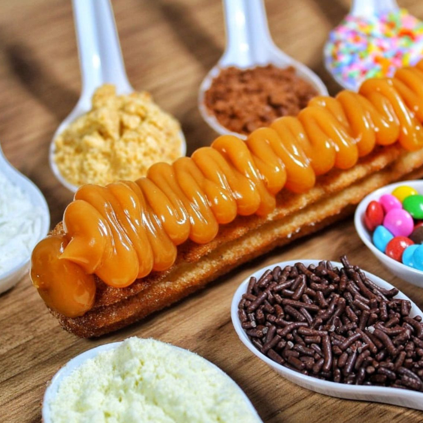 Churros gourmet, crocante e quentinho, recheado por dentro e por fora mais um topping à sua escolha.