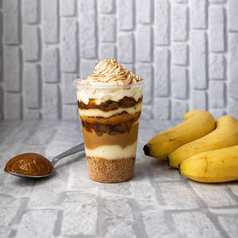 Um doce com alma de sobremesa de vó, mas cara de confeitaria! Farofa de biscoito com canela, banana caramelizada, doce de leite cremoso e chantininho com mais canela pra fechar com perfume e sabor. Um abraço doce em forma de potinho. Peso aprox: 200gr | Serve 1 pessoa