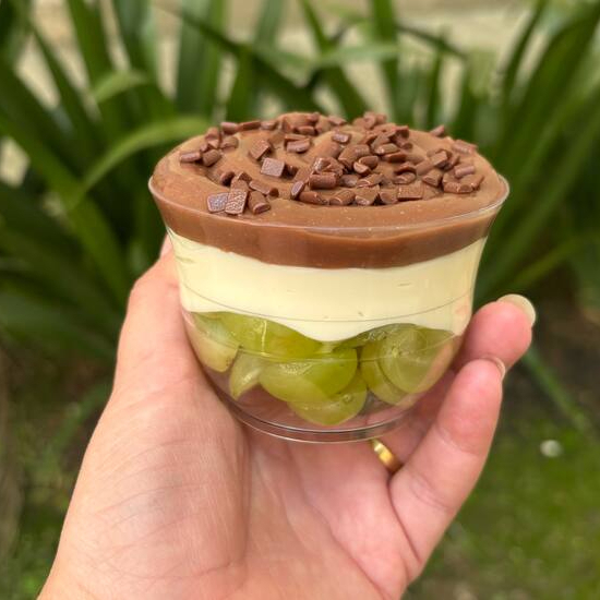 Prepare-se para uma experiência deliciosa e surpreendente com a nossa Surpresa de Uva! Desfrute de camadas do nosso cremoso brigadeiro tradicional, combinadas com o sabor suave do nosso creme de Ninho, e o toque especial da fruta, com uvas frescas e suculentas. É a combinação perfeita para quem busca um doce equilibrado e cheio de sabor. Uma verdadeira explosão de frescor e cremosidade em cada colherada!