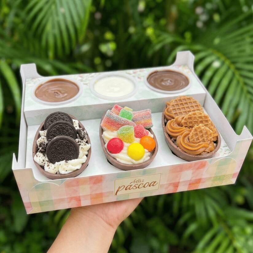 Caixa contendo 3 mini ovos (50g cada, você escolhe os sabores) e três potinhos com brigadeiro cremoso de chocolate, ninho e doce de leite. Fazendo essa compra você recebe um brinde especial <3