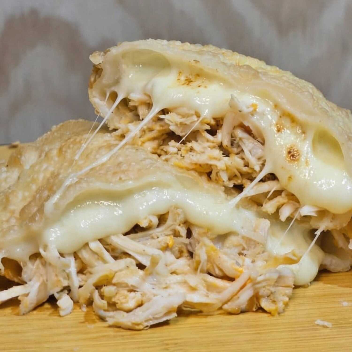 Delicioso frango desfiado com queijo mussarela, catupiry e um leve toque de orégano, suculento e temperado. Experimente essa explosão de sabores!