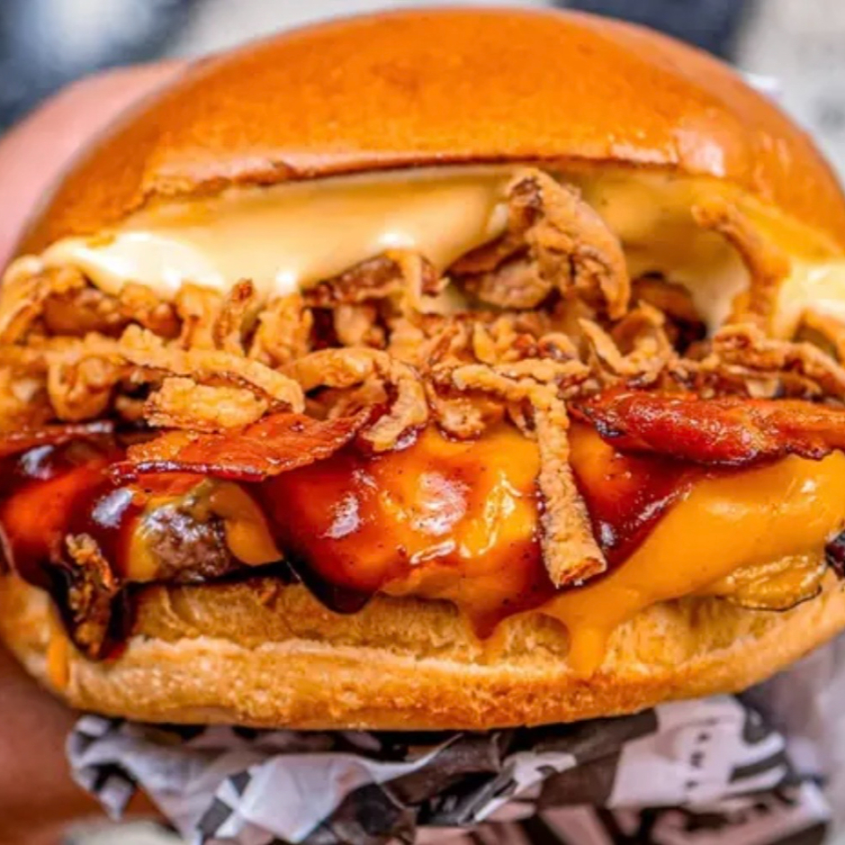 Pão de brioche, com um blend bovino de 120g, 2 fatias de queijo cheddar, cebola crispy, fatias de bacon e molho barbecue