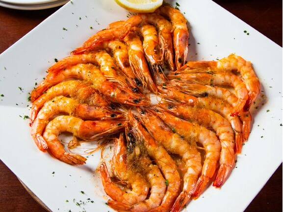 20 camarões inteiros (com cabeça) levados ligeiramente ao forno, regados com suave molho provençal. Acompanha risoto de limão siciliano. Tamanho do camarão nesse prato: 30g.