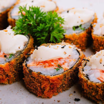 Delicioso enrolado de arroz com muito salmão e cream cheese, empanado na farinha, depois de frito cortado em 8 unidades e finalizado com molho tare artesanal