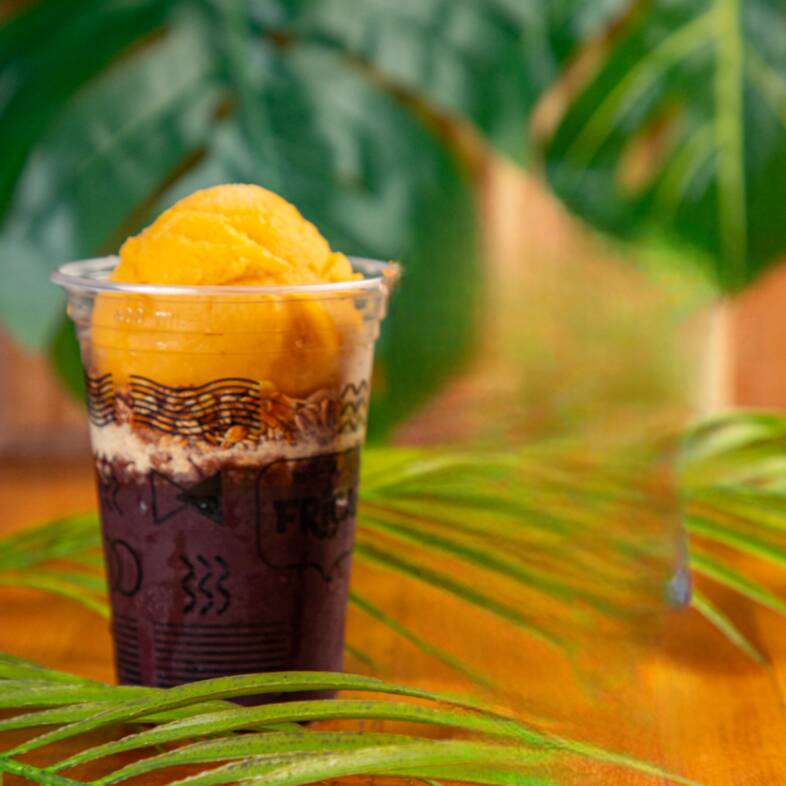 Açaí com uma bola de sorvete, granola e farofa crocante.
