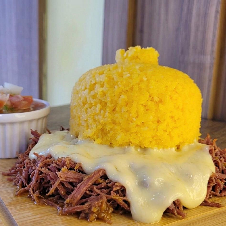 Cuscuz recheado com carne seca desfiada,queijo derretido e molho vinagrete para acompanhar..
