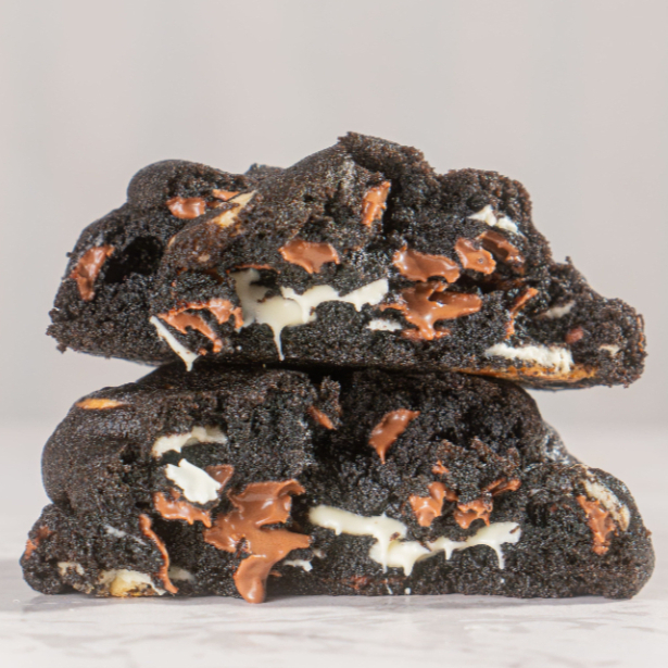 Nosso cookie de Triplo Chocolate tem massa de cacau black e é recheado com uma mistura irresistível de chocolate nobre ao leite e branco, trazendo intensidade, equilíbrio e criando um contraste único de sabores.