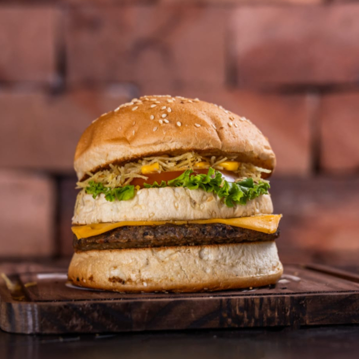 Pão, carne bovina, queijo prato, milho verde, batata palha, alface e tomate