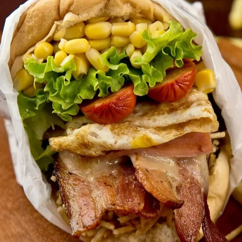 Pão, Filé de Frango, Mussarela, Apresuntado, Bacon, Tomate, Alface, Milho e Batata Palha.