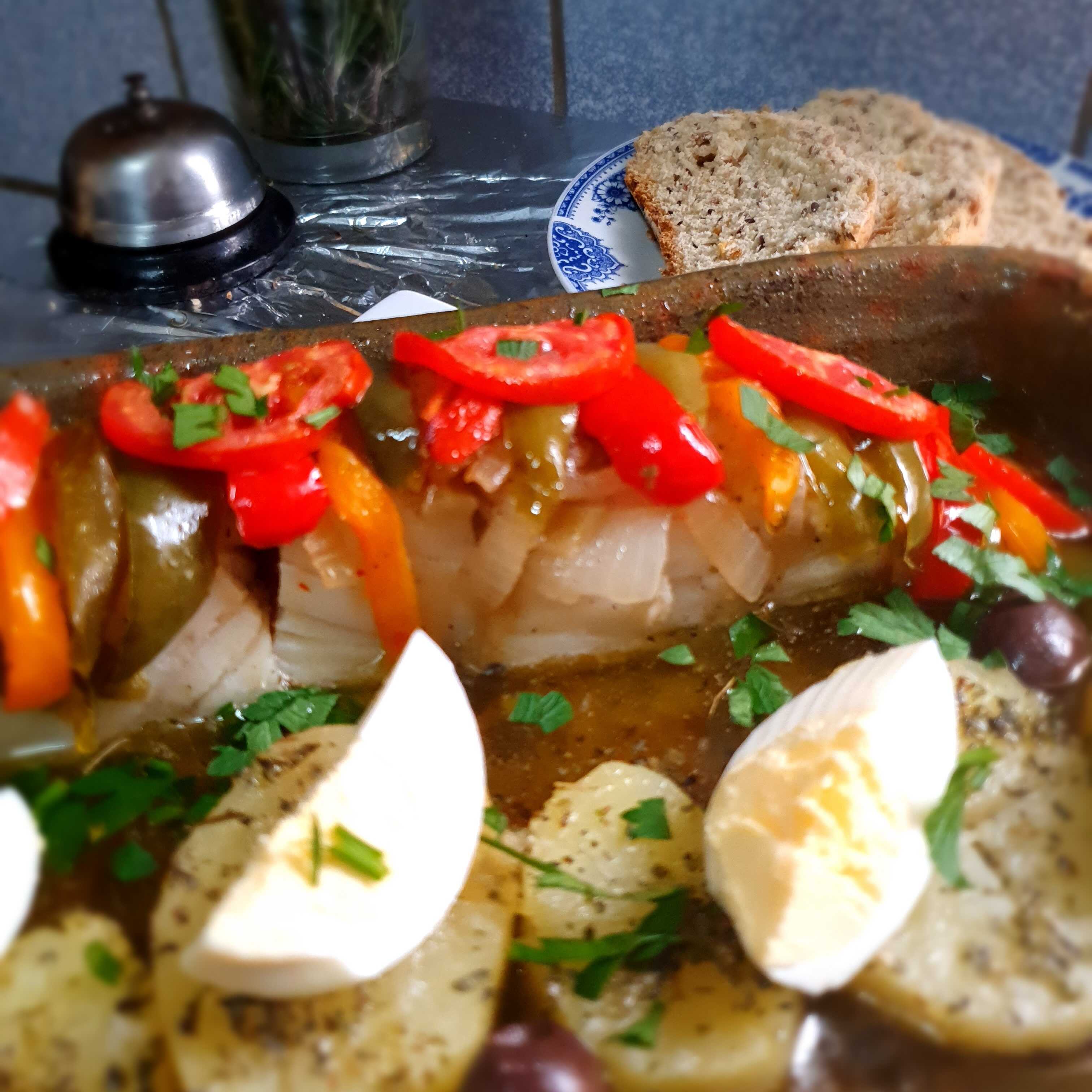Lombo de bacalhau com cebola, pimentões, batata e ovo cozido, regado no azeite e assado no forno. Acompanha pão caseiro. Serve 1 pessoa
